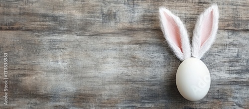 Obraz na płótnie Easter bunny ears with pink inner lining positioned left of a white egg on a rustic wooden background with ample copy space on the right w salonie