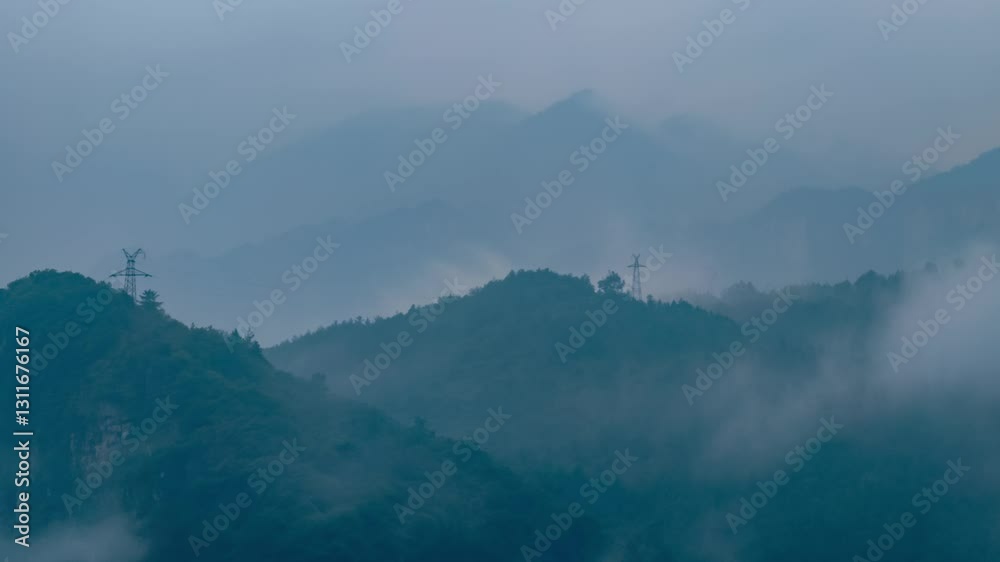 A time-lapse of white clouds floating around a mountaintop full of power pylons A time-lapse of white clouds floating around a mountaintop full of power pylons