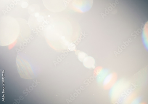 Soft lens flare and bokeh against a grainy grey backdrop, white light orbs with subtle rainbow spectral