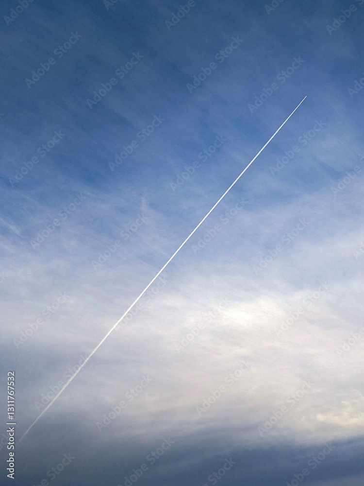 A contrail left by an aircraft streaking across the tranquil azure sky with cirrus clouds. Captures movement and serenity in an expansive atmospheric scene. A contrail left by an aircraft streaking across the tranquil azure sky with cirrus clouds. Captures movement and serenity in an expansive atmospheric scene.