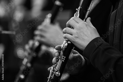 Clarinet in the hands of a musician in an orchestra in black and white