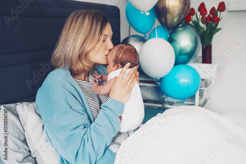 After baby delivery mother and baby at home. Mother holds her newborn in hands. Mom and baby together. Childbirth and motherhood concept. Family celebrates birth of baby boy.