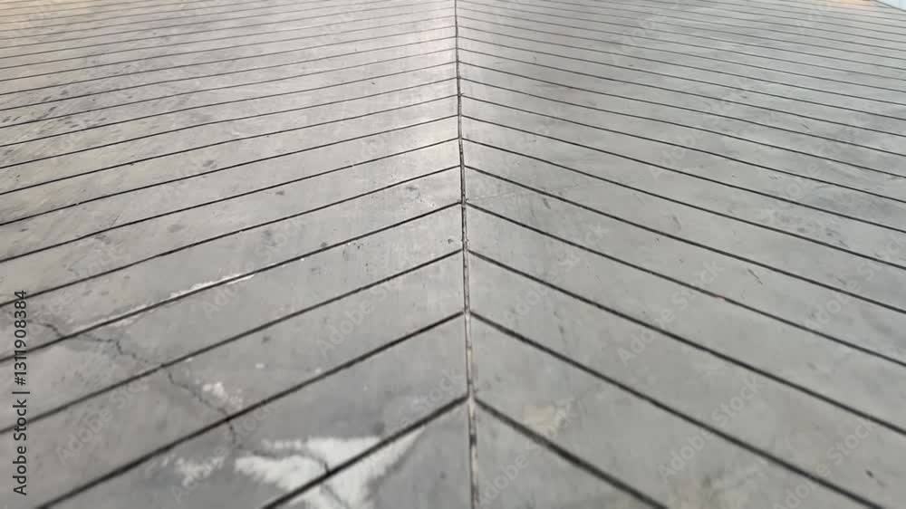 Top view of cement walking path surface with rough texture, small stones, and cracks from outdoor wear.
Top view of cement walking path surface with rough texture, small stones, and cracks from outdoor wear.