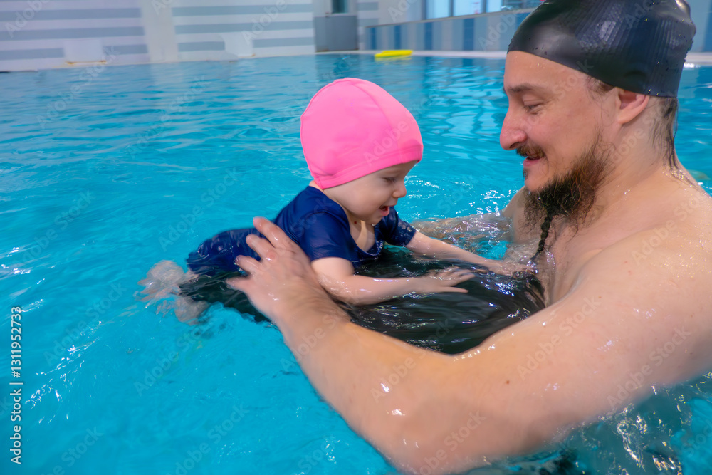 Happy middle-aged father swimming with cute adorable baby in swimming pool. Smiling dad and little child, girl having fun together. Active family spending leisure and time in spa hotel. Concept of