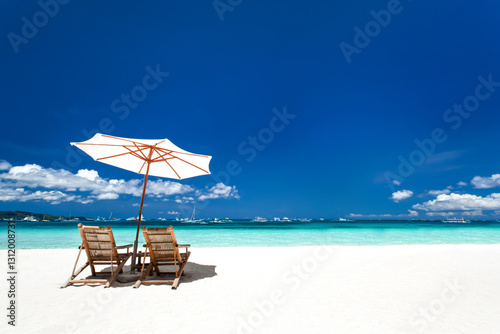 Fototapeta Naklejka Na Ścianę i Meble -  Sun umbrellas and wooden beds on tropical beach
