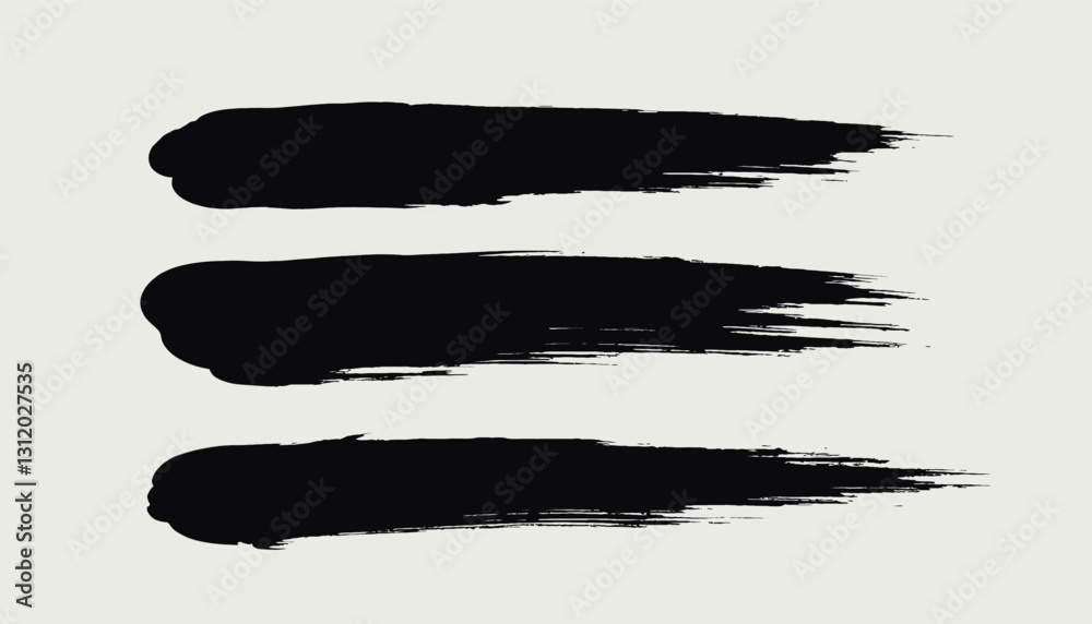 Fototapeta premium Three black textured paint brush strokes on white
