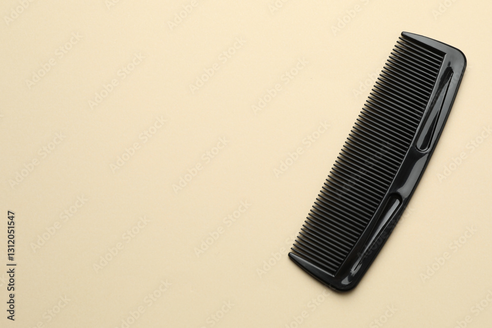 One black plastic comb on beige background, top view. Space for text One black plastic comb on beige background, top view. Space for text
