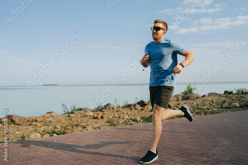 Running with purpose near a serene lakeside, a man enjoys the health benefits and tranquility of early morning.