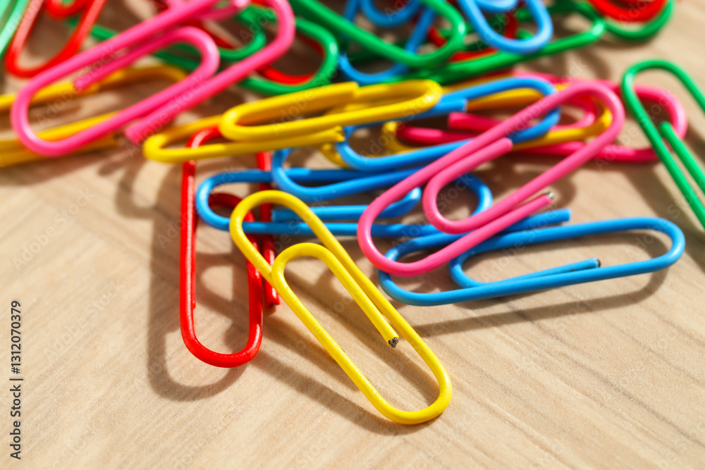 Many colorful paper clips on wooden table, closeup Many colorful paper clips on wooden table, closeup