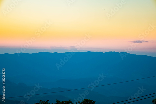 The stunning view from a tourist's standpoint as they go down a hill on a foggy trail with a hill and a background of a golden sky in Forest Park, Thailand. Rainforest. Bird's eye view. Aerial view.