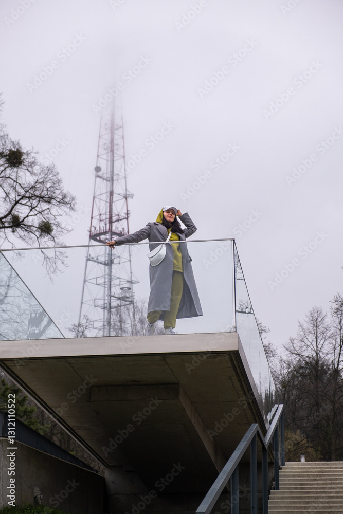 stylish woman on outdoors balcony at fogy weather
