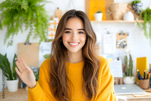 Cheerful woman waving in a plant-filled, bright home office setting