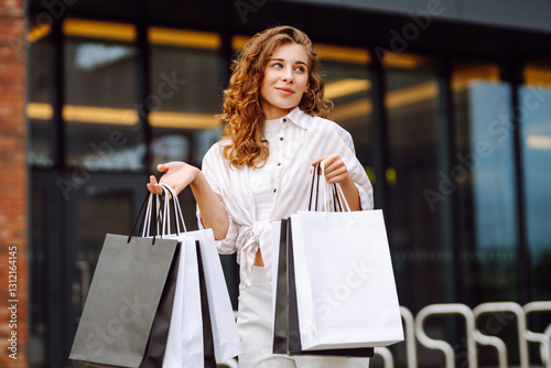 Εκτύπωση καμβά Young woman with shopping bags having fun near the mall