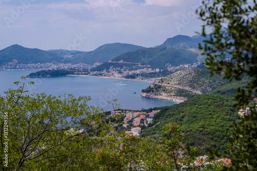 overlooking the town of Budva and the boat in sea with mountains and green forest in the background. High quality photo