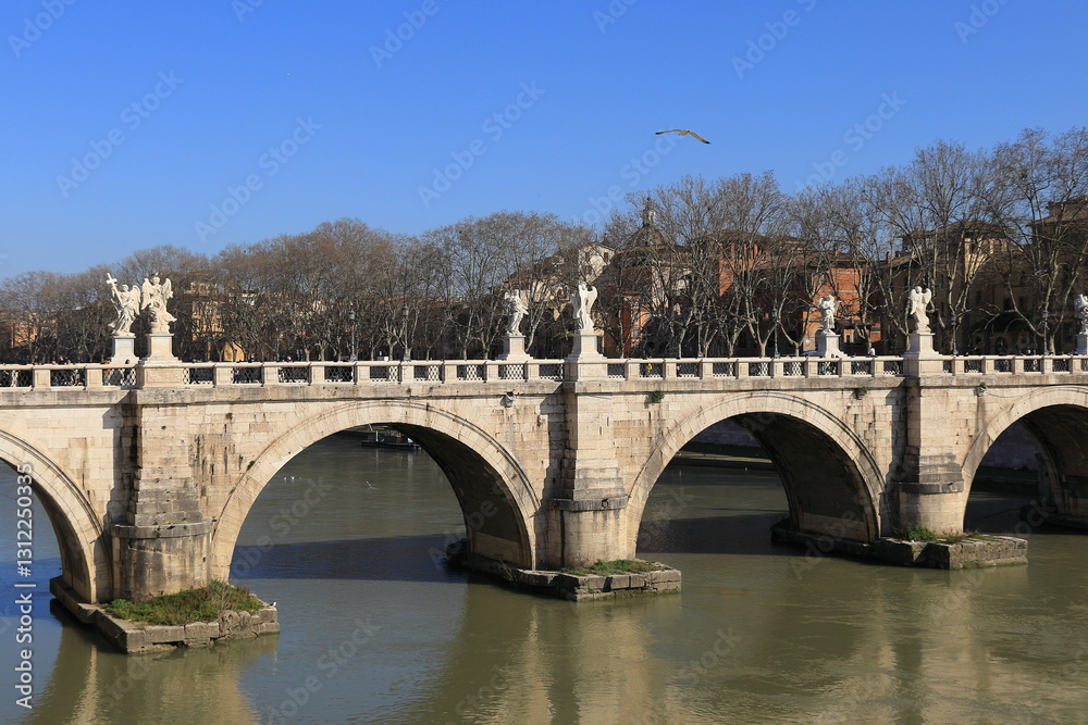 Tiber River View with Ponte Sant'Angelo Bridge, Bare Trees and Blue Sky in Rome, Italy, March 2025 Tiber River View with Ponte Sant'Angelo Bridge, Bare Trees and Blue Sky in Rome, Italy, March 2025