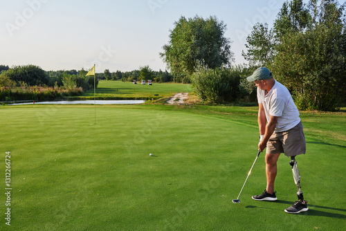 A golfer with a prosthetic leg prepares to putt on the green amidst the lush landscape and clear blue skies at the golf course