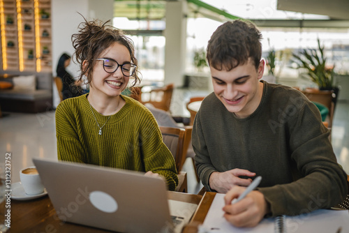 young couple work together and learn on laptop at cafe
