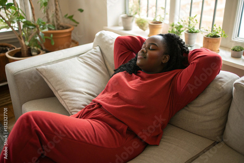 plump african-american woman in red long-sleeved top toprelaxing on a couch