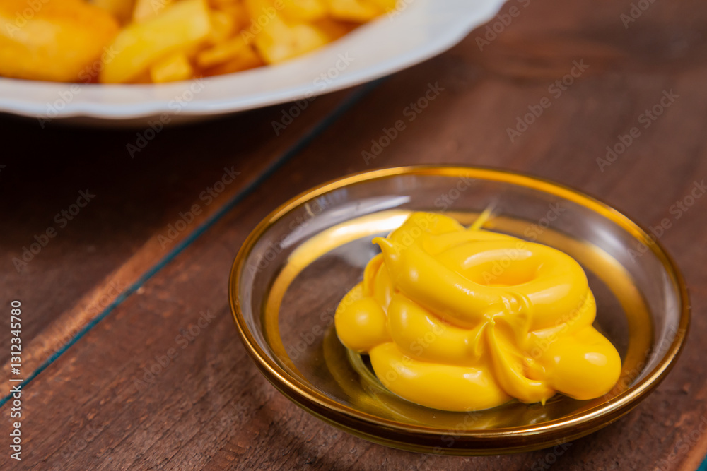 French fries and golden nuggets with cheese sauce on a wooden table French fries and golden nuggets with cheese sauce on a wooden table