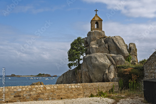 The Sentinel rock in Port-Blanc is very characteristic with its oratory surmounted by a cross in Brittany, France photo
