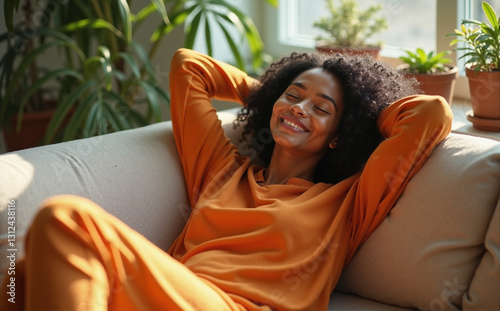 african-american woman in orange long-sleeved top toprelaxing on a couch