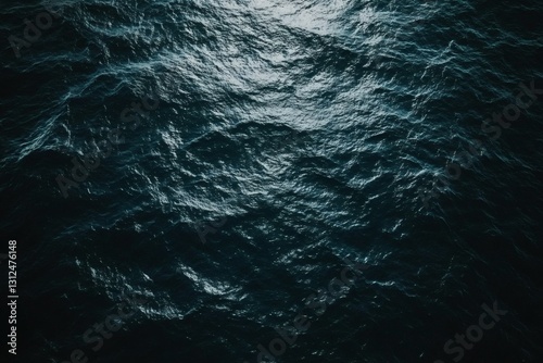 Abstract aerial view of dark blue ocean surface with sparkling light