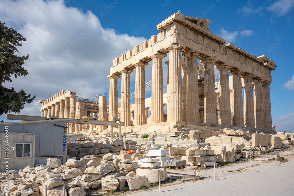 Obraz premium Architectural masterpiece, the Parthenon, a unique UNESCO world heritage archaeological site of Acropolis hill with beautiful scattered clouds and deep blue sky, Athens historic center, Attica, Greece