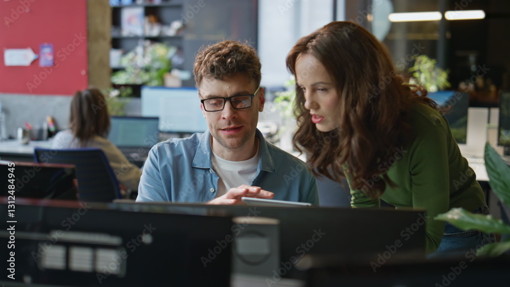 Focused colleagues looking monitor discussing business results in agency closeup Focused colleagues looking monitor discussing business results in agency closeup