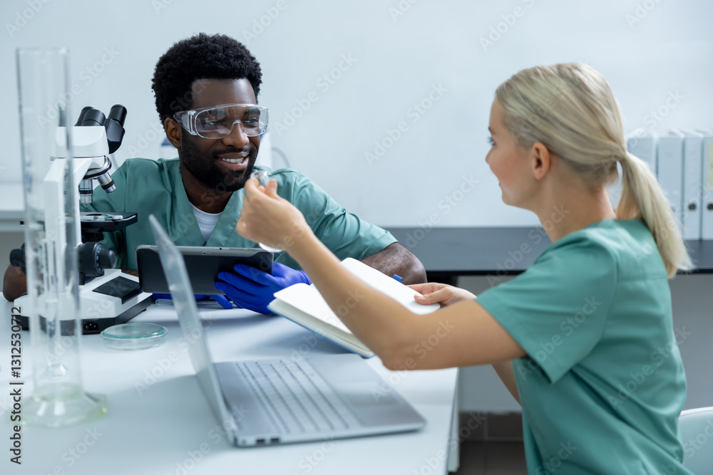 Obraz premium Colleagues scientists diligently working in modern laboratory using microscope and laptop