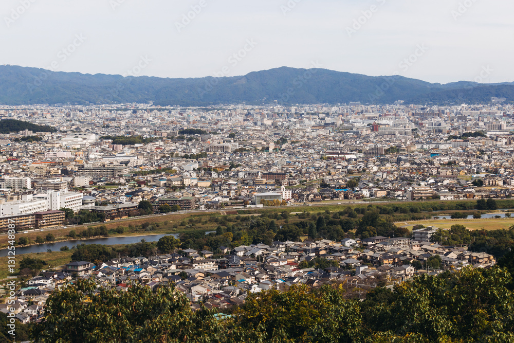 Fototapeta premium Kyoto panorama, Japan, beautiful super wide aerial view, with city skyline and mountains, seen from the observation deck in autumn fall sunny day with a blue sky, Kyoto prefecture, Kansai region