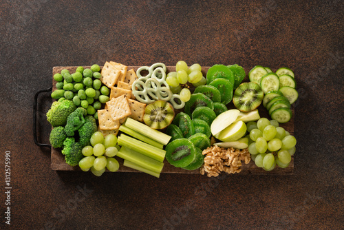 St Patricks day charcuterie board decorated shamrock and clover leaf on brown background. View from above. Festive holiday appetizer for celebration.
