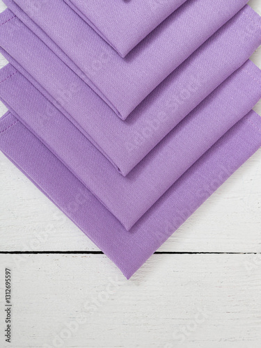 Purple napkins on a wooden white background. Closeup.