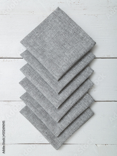 Grey napkins on a wooden white background. Closeup.