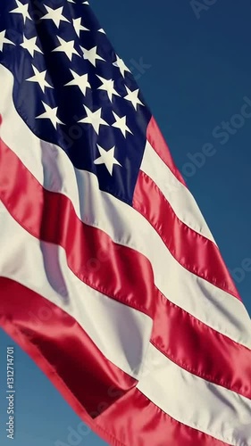 Majestic american flag waving against clear blue sky in slow motion sequence