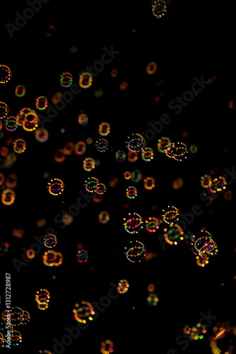 Floating iridescent bubbles with colorful glowing bokeh at night