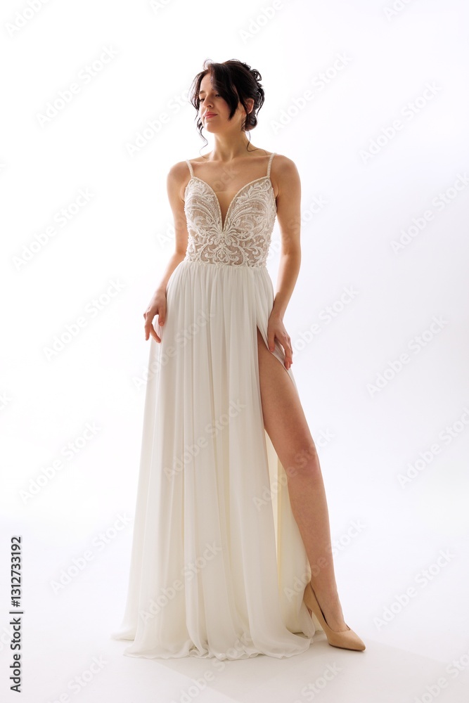 Model showcases elegant white evening gown with intricate detailing in a stylish photoshoot setting Model showcases elegant white evening gown with intricate detailing in a stylish photoshoot setting