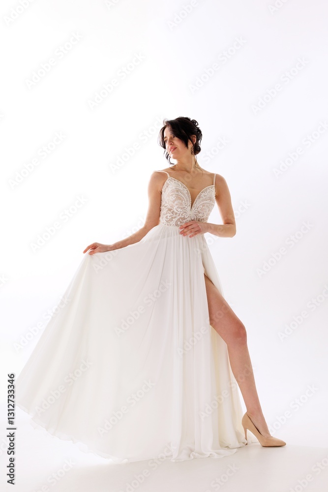 Elegant woman in white gown showcasing beauty and grace during a photoshoot in a well-lit studio environment Elegant woman in white gown showcasing beauty and grace during a photoshoot in a well-lit studio environment