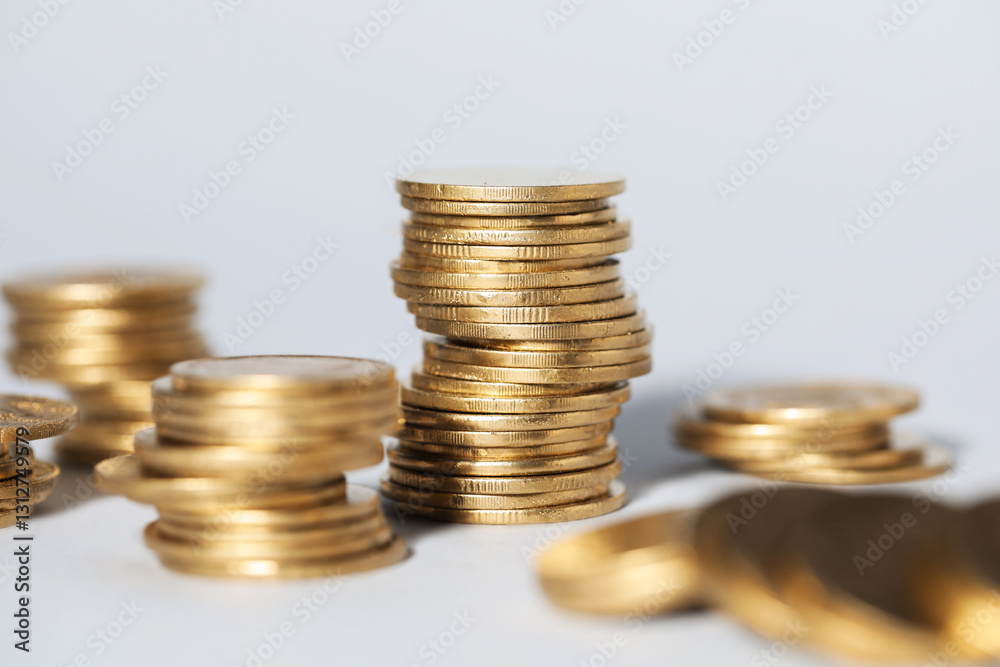 Many stacked coins on light grey background, closeup Many stacked coins on light grey background, closeup