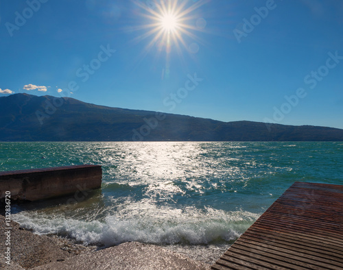 Fototapeta Naklejka Na Ścianę i Meble -  summer scenery, blue lake Gardasee rolling waves, beach Gial, Gargnano
