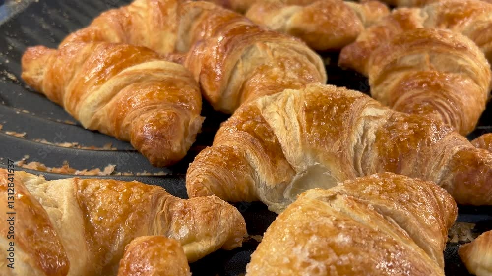 Freshly baked croissants, tracking shot on golden crunchy croissant displayed on baker's shelf