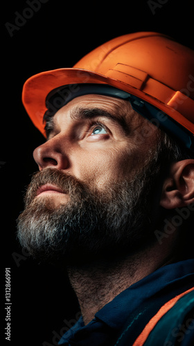 Wallpaper Mural Hardhat-wearing construction worker standing tall, looking skyward with resolute strength against deep black backdrop Torontodigital.ca