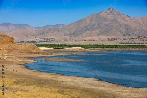 A scenic view of Lake Isabella in California, USA, showcasing the low water levels due to drought. The arid landscape and distant mountains highlight environmental..  Kernville, California, USA photo