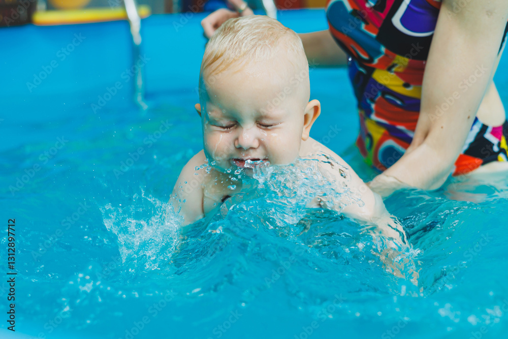 Pool for swimming babies under the supervision of a trainer. Young mother with a child in the pool. Woman holding a baby, having fun in the water Pool for swimming babies under the supervision of a trainer. Young mother with a child in the pool. Woman holding a baby, having fun in the water