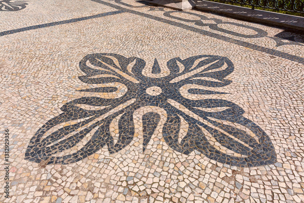 Decorative Portuguese pavement with black and white stone patterns carved on the Miradouro de Santa Catarina in Lisbon, Portugal