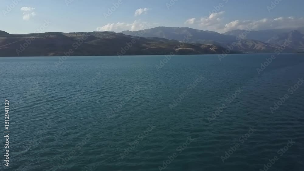 A drone flies over a blue mountain lake. Sunny summer day A drone flies over a blue mountain lake. Sunny summer day