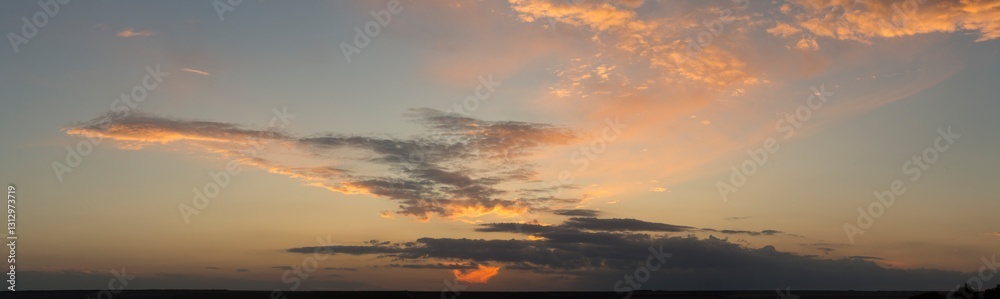 Naklejka premium Landscape at sunset. Tragic gloomy sky. Panorama. Crimson twilight. Heavy, gloomy, dark clouds.
