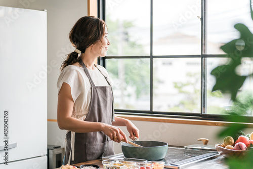 キッチンで料理をする若いアジア人女性（クッキング・手料理）
