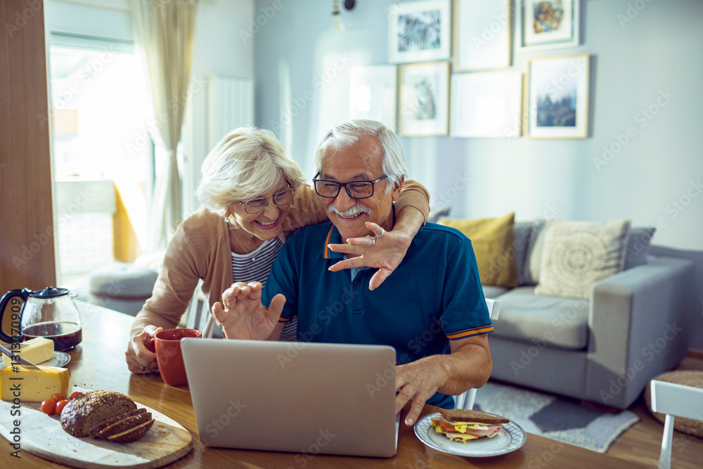 Happy senior couple waving during video call at home Happy senior couple waving during video call at home