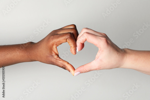 Stop racism. People of different skin colors making heart with hands on light grey background, closeup
