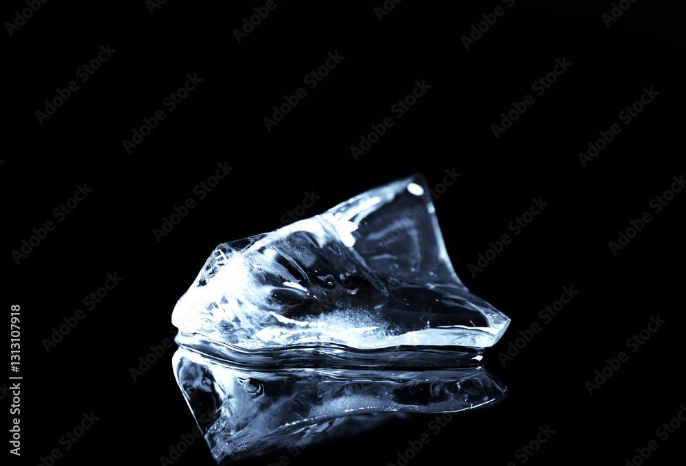 Naklejka premium Piece of clear ice on black mirror surface